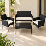 Juego de terraza 2+1+1 en tejido negro con cojines crema: sofá de 2 puestos, 2 sillones y mesa, ambientado en una terraza