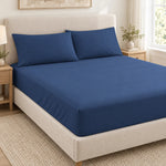 Forro ajustable liso con 2 sobrefundas bordadas, color Azul Navy – forro ajustable y 2 sobrefundas en la cama