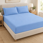 Forro ajustable liso con 2 sobrefundas bordadas, color Celeste – forro ajustable y 2 sobrefundas en la cama
