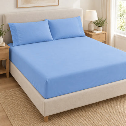 Forro ajustable liso con 2 sobrefundas bordadas, color Celeste – forro ajustable y 2 sobrefundas en la cama
