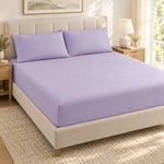 Forro ajustable liso con 2 sobrefundas bordadas, color Lila – forro ajustable y 2 sobrefundas en la cama