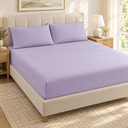 Forro ajustable liso con 2 sobrefundas bordadas, color Lila – forro ajustable y 2 sobrefundas en la cama