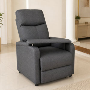 Sillón reclinable tapizado en gris con bandeja abatible integrada, vista frontal en sala