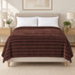 Frazada full chocolate de 180 x 220 cm con rayas en relieve – vista frontal sobre la cama