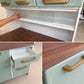 Detalles de la alacena de cocina Bertolini: vitrina corrediza de vidrio, cajón abierto con guía metálica y tirador dorado sobre el tablero de madera