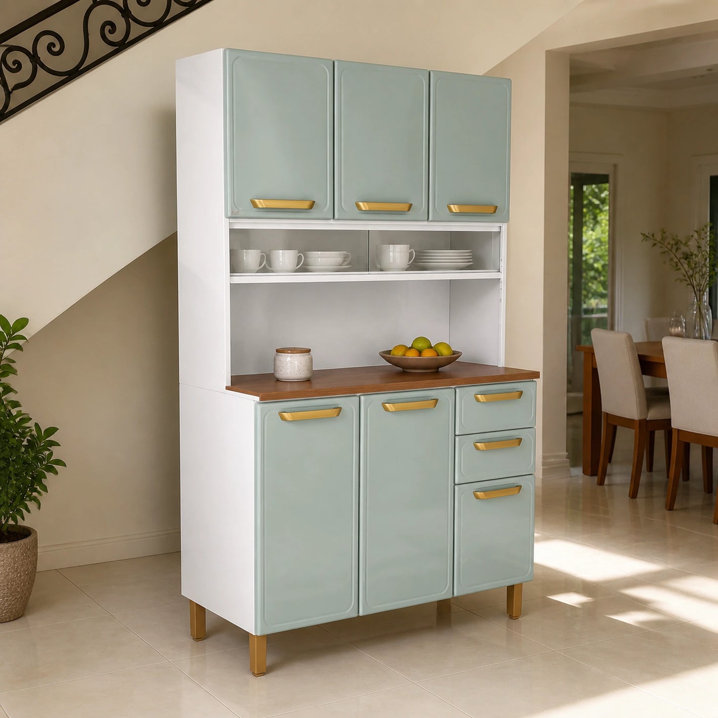 Alacena de cocina Bertolini verde menta ambientada en un pasillo interior, con tazas y platos exhibidos en la vitrina corrediza y frutas sobre el tablero