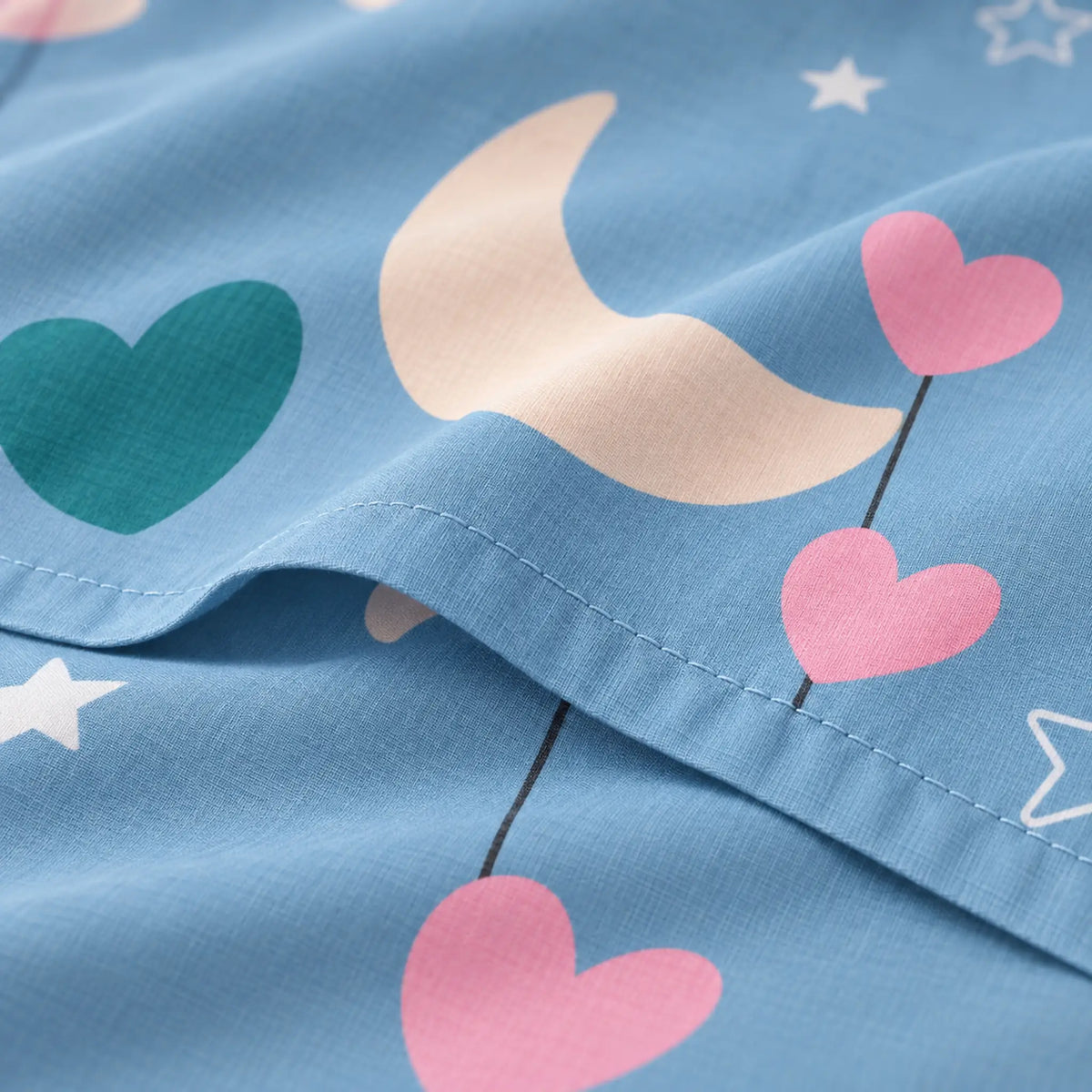 Juego de sábanas con vuelo 4 piezas, diseño Lunas y Corazones Azul – detalle de la tela