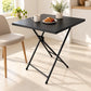 Mesa plegable negra con café y desayuno en una cocina iluminada