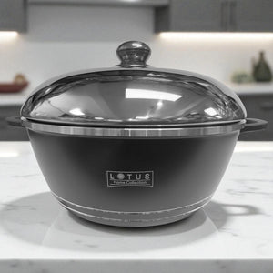 Olla negra de aluminio forjado Lotus Home Collection de 28 cm con tapa cerrada, sobre encimera de mármol en cocina moderna