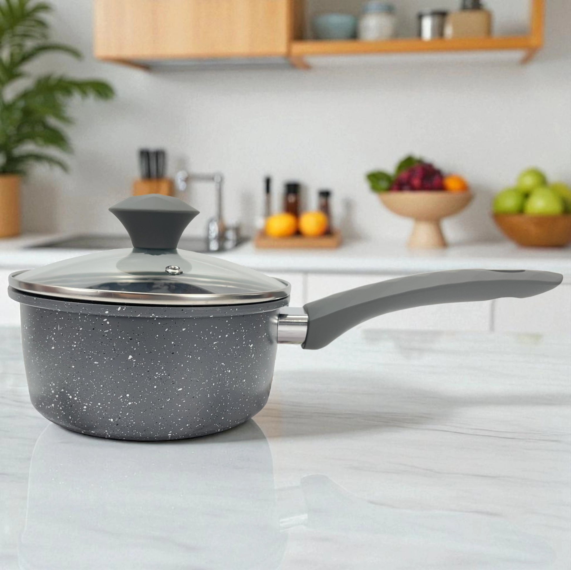 Cacerola con tapa de vidrio del set Big Home, mostrada en cocina moderna, con mango largo ergonómico.