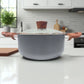 Vista frontal de la olla Proctor Silex Dutch Oven 3.6 L con tapa colocada, mostrando su diseño moderno en color gris y mangos estilo madera.