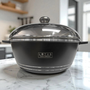 Olla de aluminio forjado negra Lotus Home Collection de 28 cm con tapa cerrada, vista frontal sobre encimera de cocina moderna