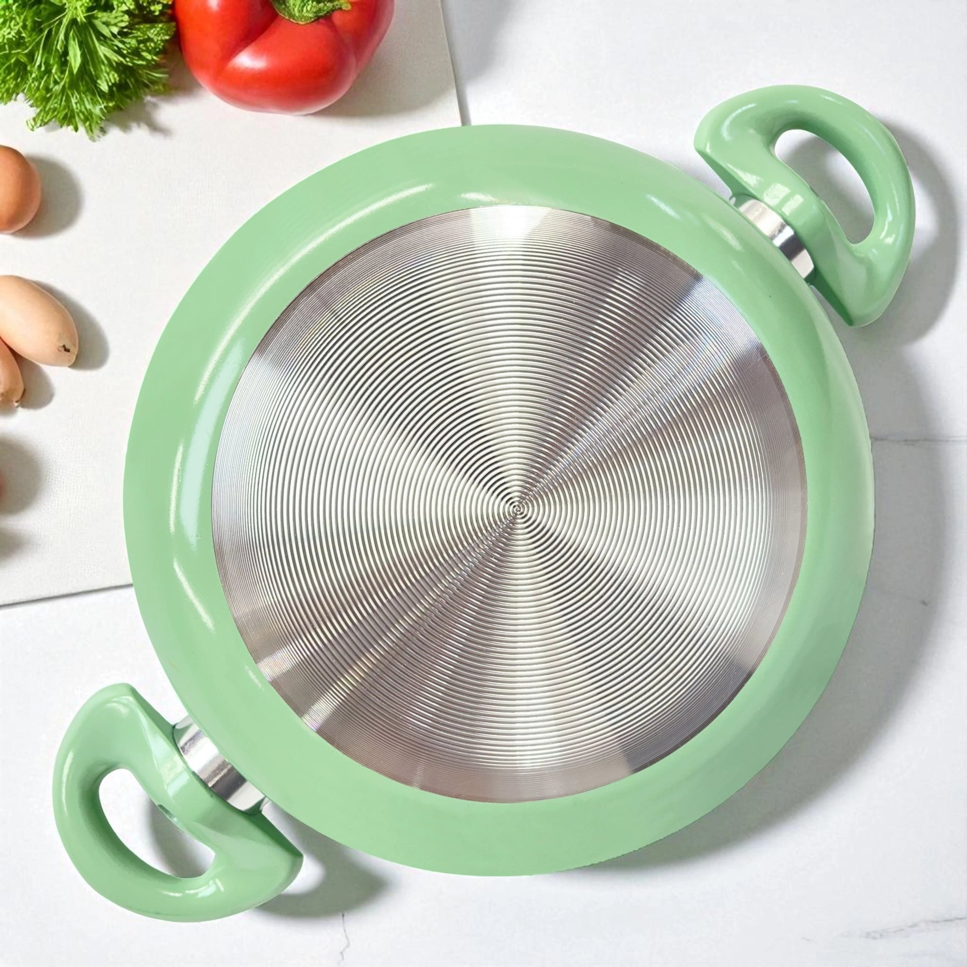 Vista inferior de olla verde con base metálica para cocinas de inducción, marca Lotus Home Collection