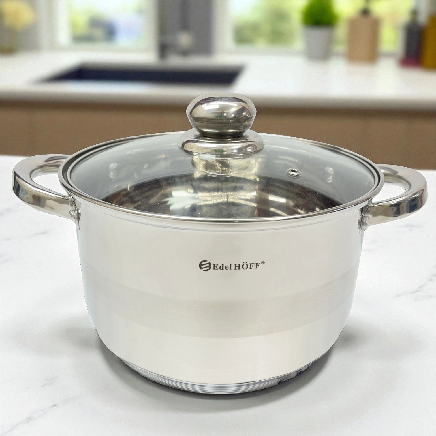 Olla de acero inoxidable Edel HÖFF de 26 cm con tapa de cristal, sobre encimera blanca