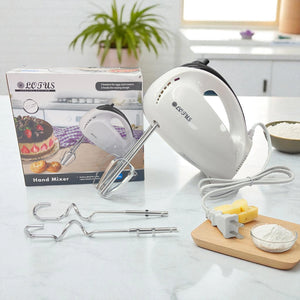 Batidora de mano Lotus blanca con detalles negros, caja del producto y accesorios incluidos sobre superficie blanca con ingredientes