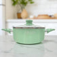 Olla mediana verde con tapa de vidrio y mangos ergonómicos, ideal para uso diario en cocina.