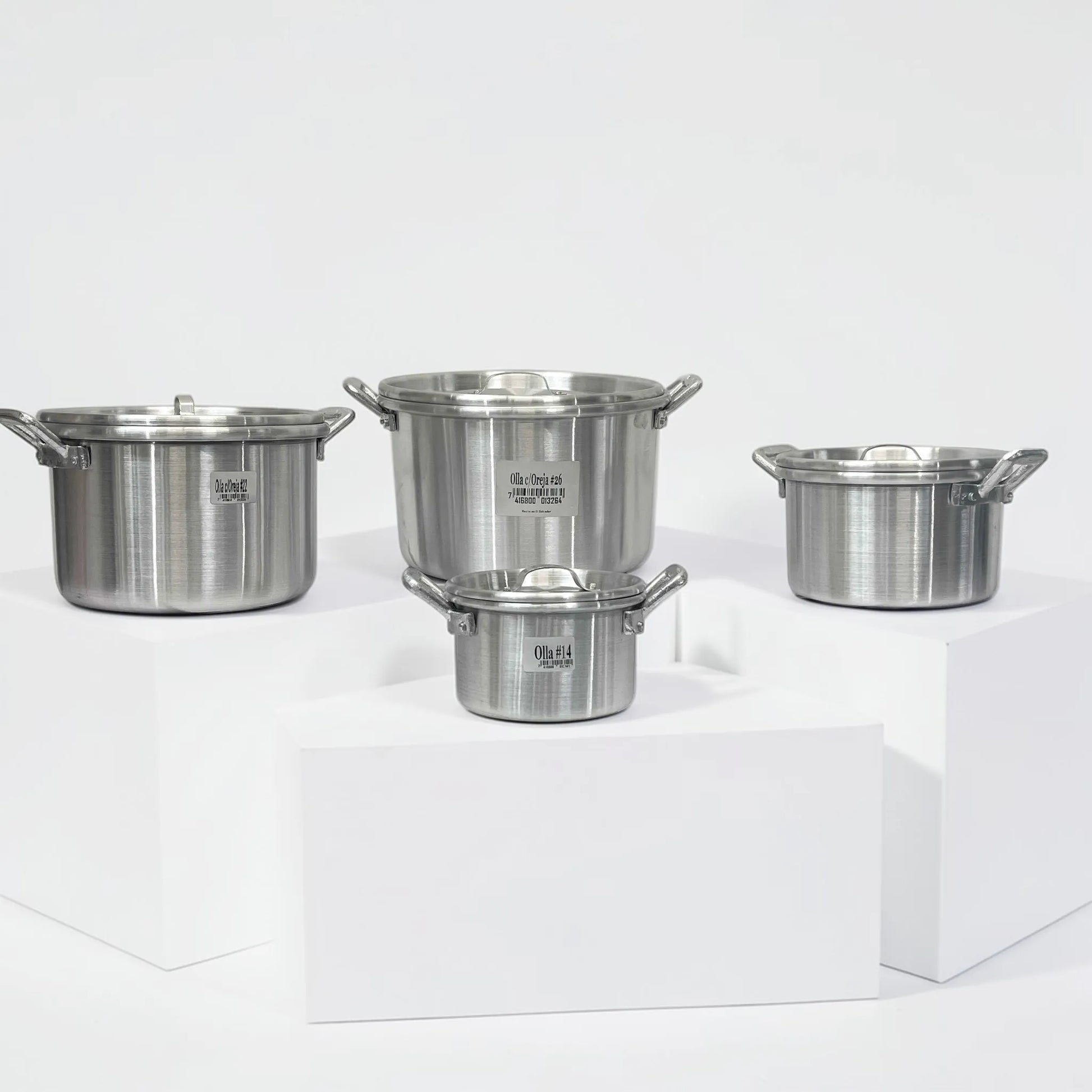 Set completo de 4 ollas de aluminio ALINTER con oreja y tapa (#14 #18 #22 #26), color plateado, hechas en El Salvador, presentado en fondo blanco.