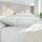 Vista lateral de almohada Aloe Vera Scarlett Classics Standard 51x66 cm mostrando grosor, volumen, borde verde y textura blanca acolchada sobre cama.