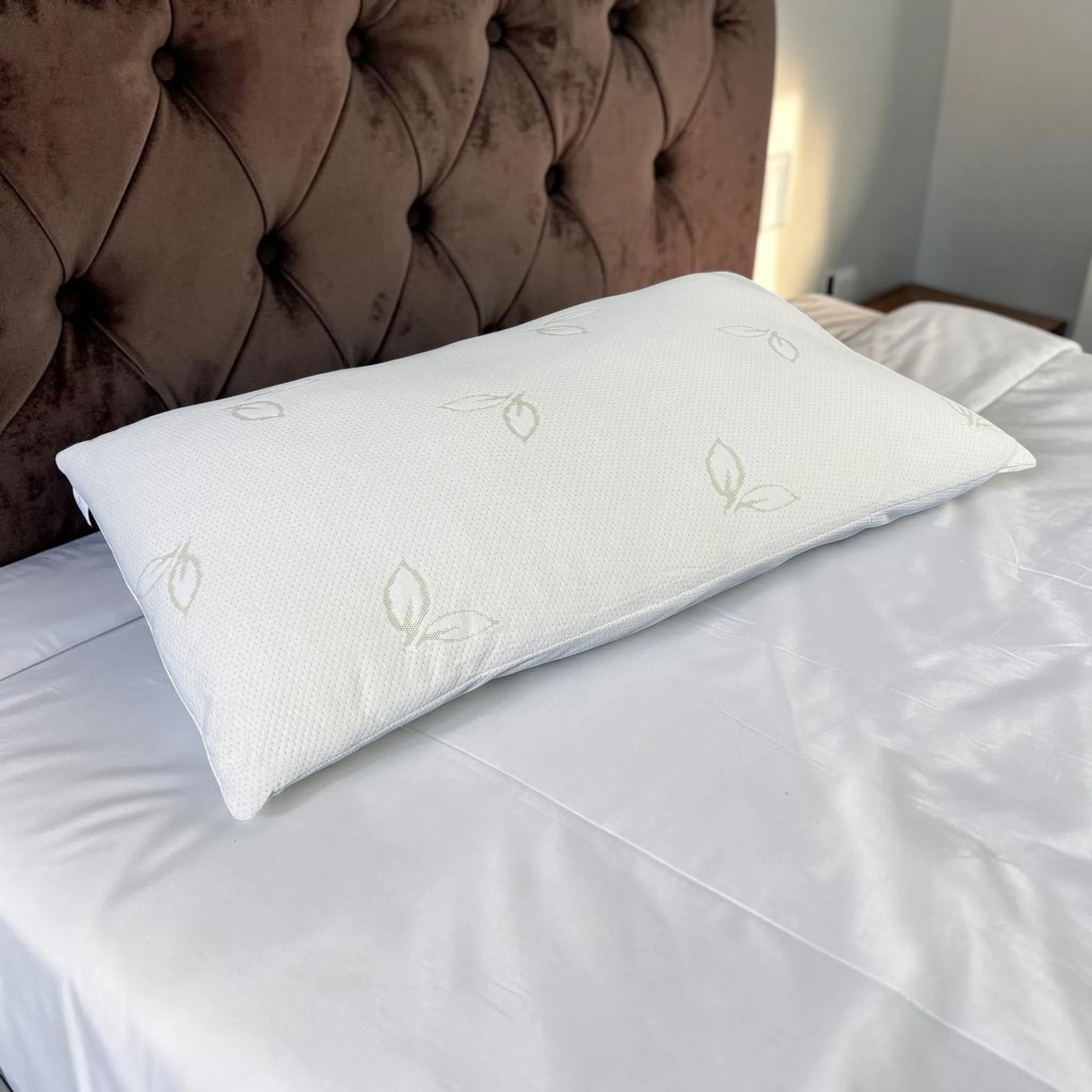 Almohada de bambú Pacific Home blanca de 50 x 90 cm fotografiada en perspectiva diagonal sobre una cama, mostrando su longitud, volumen y textura.