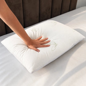 Mano presionando una almohada de bambú Pacific Home blanca para mostrar la suavidad, adaptabilidad y recuperación de su relleno.