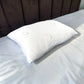 Almohada de bambú Pacific Home blanca fotografiada en perspectiva diagonal sobre una cama, mostrando su forma, volumen y tela transpirable.
