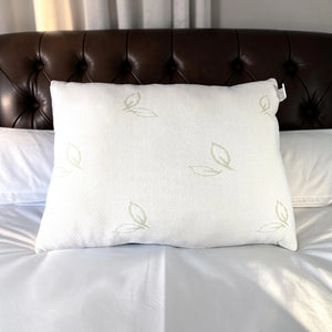 Almohada de bambú Pacific Home color blanco mostrada de frente sobre una cama, con tela transpirable y diseño de hojas verdes.