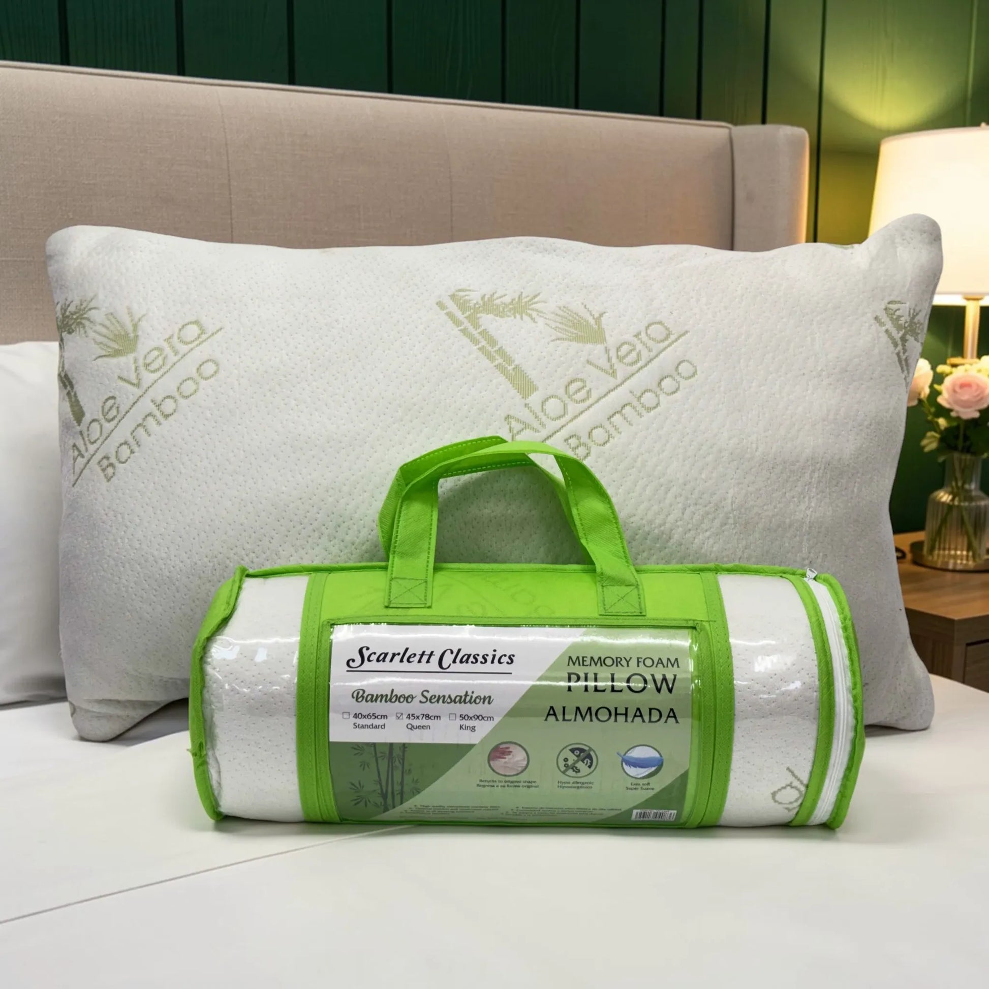 Almohada de memory foam blanca con funda de bambú al fondo y empaque verde Scarlett Classics al frente, vista frontal en dormitorio.