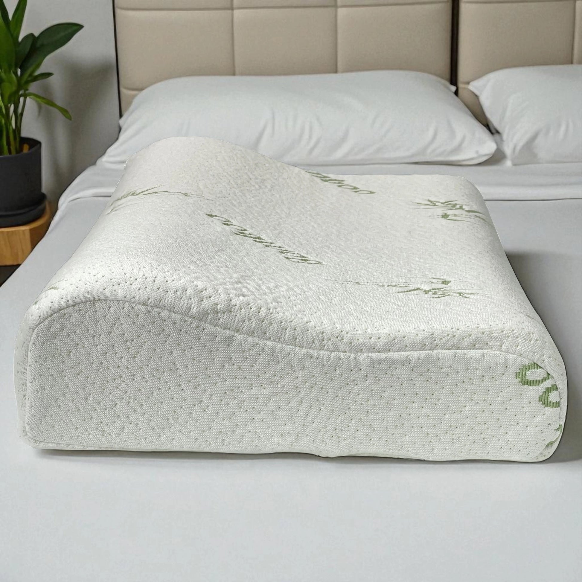 Vista lateral de la almohada ortopédica memory foam con funda de bambú sobre cama blanca, marca Casa Opal, tamaño 47x30 cm