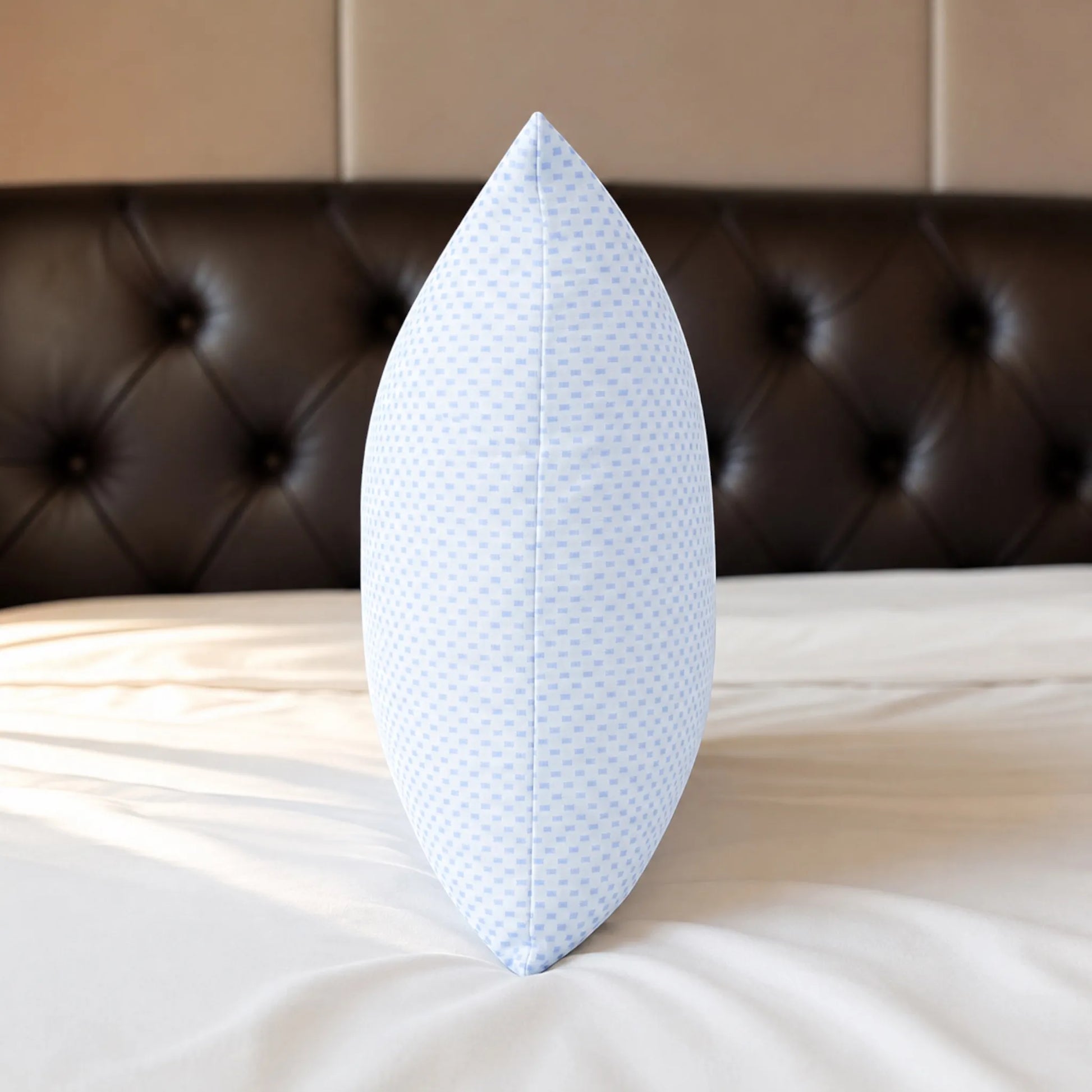 Almohada refrescante Pacific Home blanca con patrón celeste colocada verticalmente para mostrar su grosor, volumen y costura central.