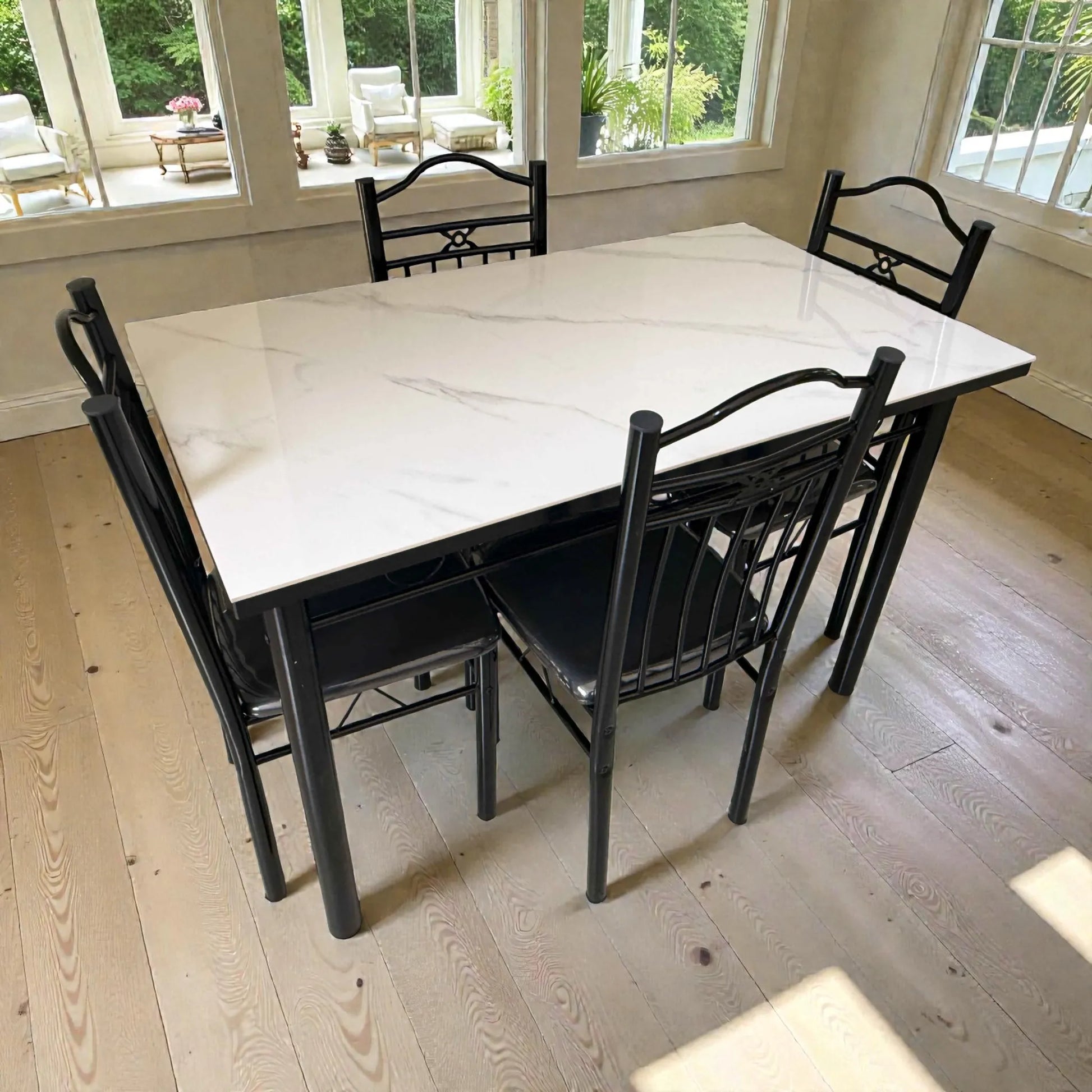 Comedor 4 puestos DT-Y7007 con mesa tipo mármol blanco y estructura metálica negra, vista lateral cerca de ventanales con luz natural.