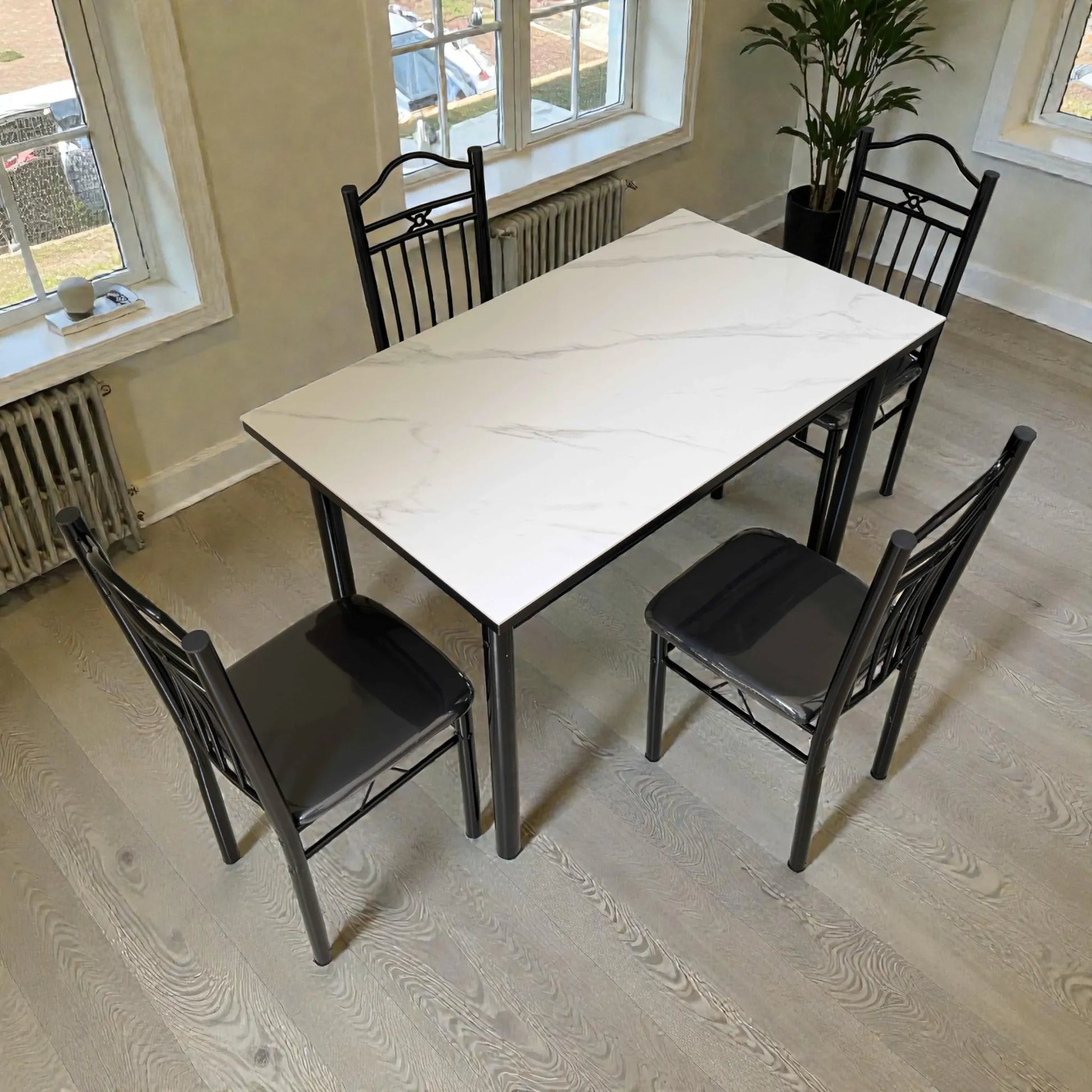 Vista diagonal del comedor 4 puestos DT-Y7007 Ambienta Home Decor: mesa rectangular con cubierta tipo mármol blanco y sillas negras.