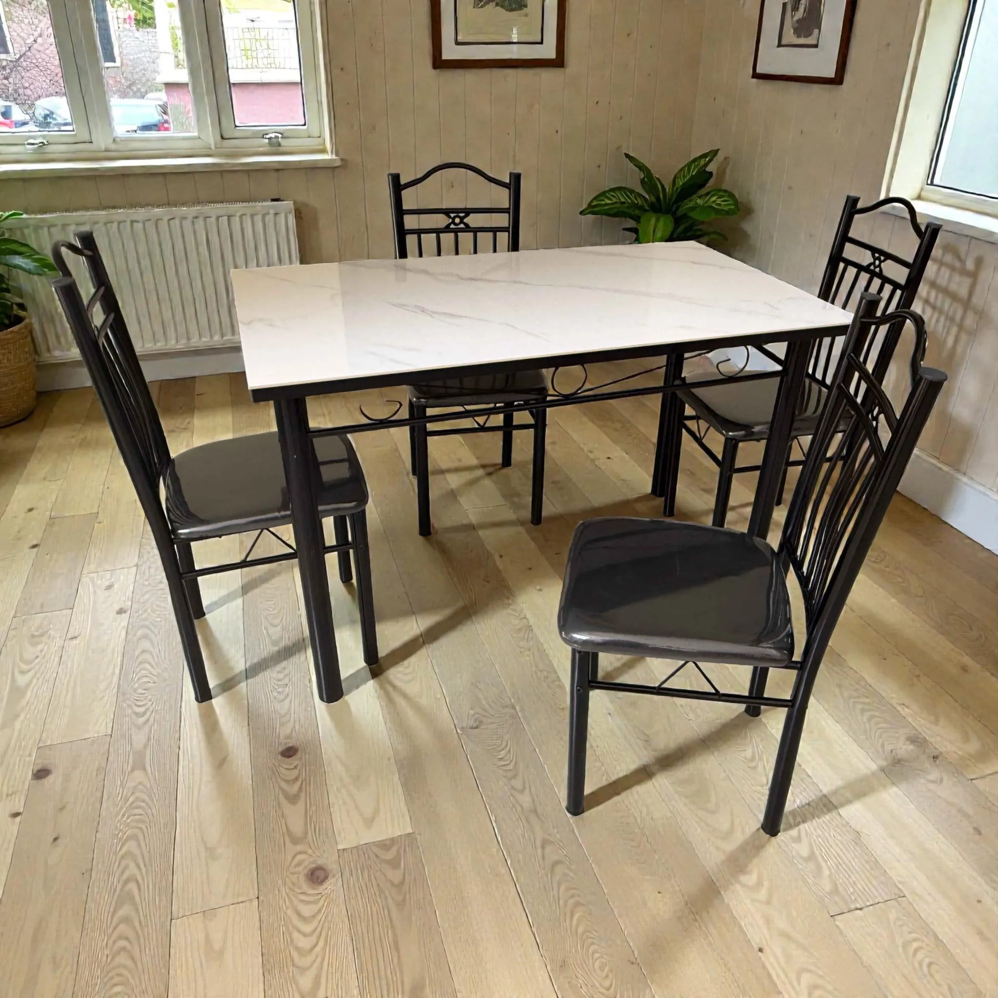 Vista lateral del comedor 4 puestos DT-Y7007: mesa 120x70 cm con cubierta tipo mármol blanco, estructura metálica negra y 4 sillas negras.