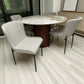 Vista superior del juego de comedor DT-04-2258 con mesa Ø120 cm efecto mármol y base nogal, sillas beige y aparador tono roble al fondo.