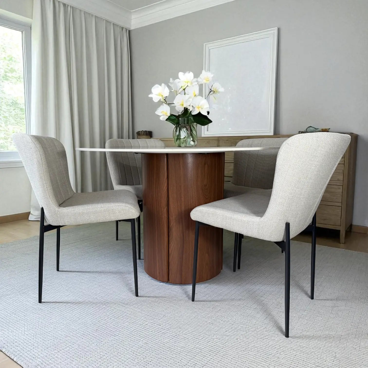 Mesa redonda Ø120 cm efecto mármol con base cilíndrica en nogal y sillas tapizadas beige (patas metálicas negras), modelo DT-04-2258, vista lateral derecha con florero.