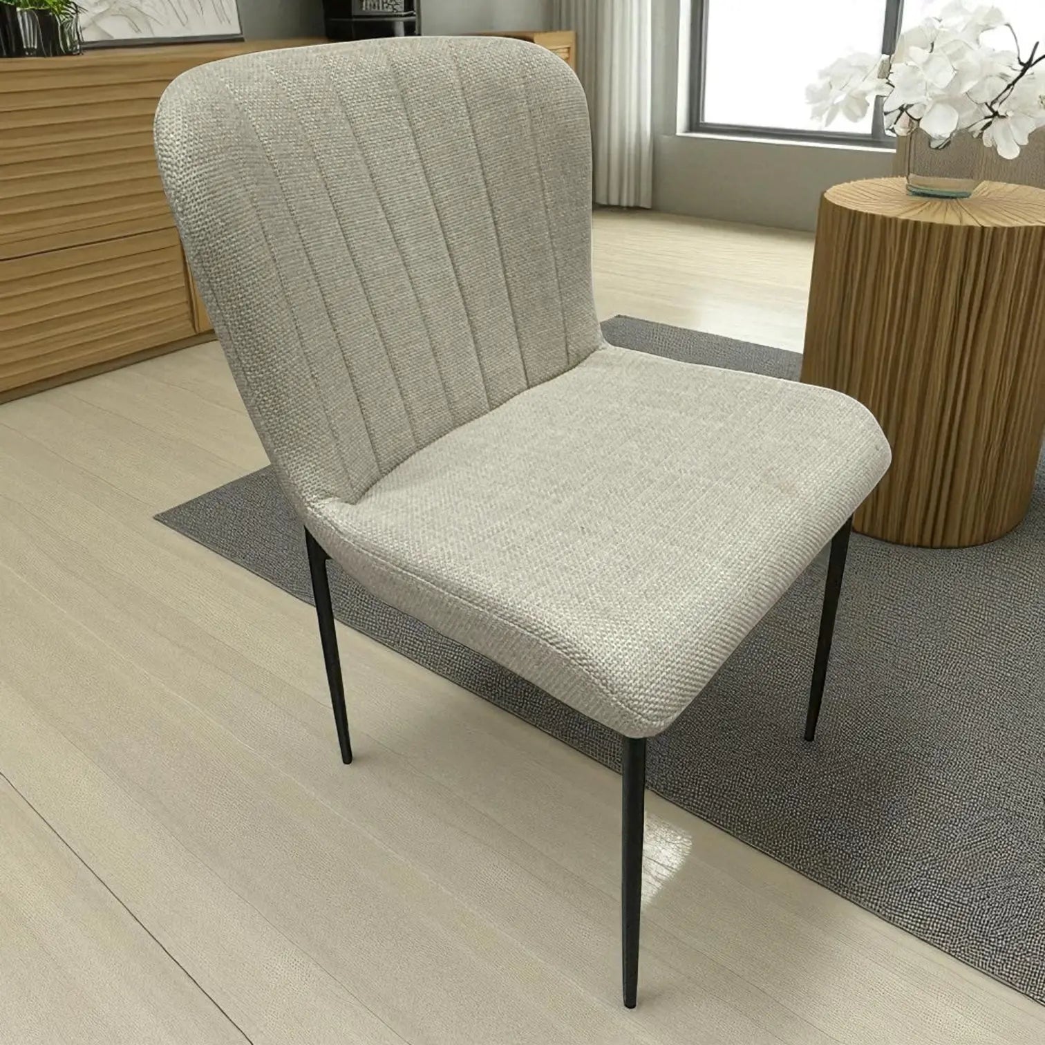 Silla de comedor DT-04-2258 en perspectiva tres cuartos; tapizado beige con costuras verticales, asiento ergonómico, patas metálicas negras; asiento 48 cm de ancho, altura de asiento 40 cm.