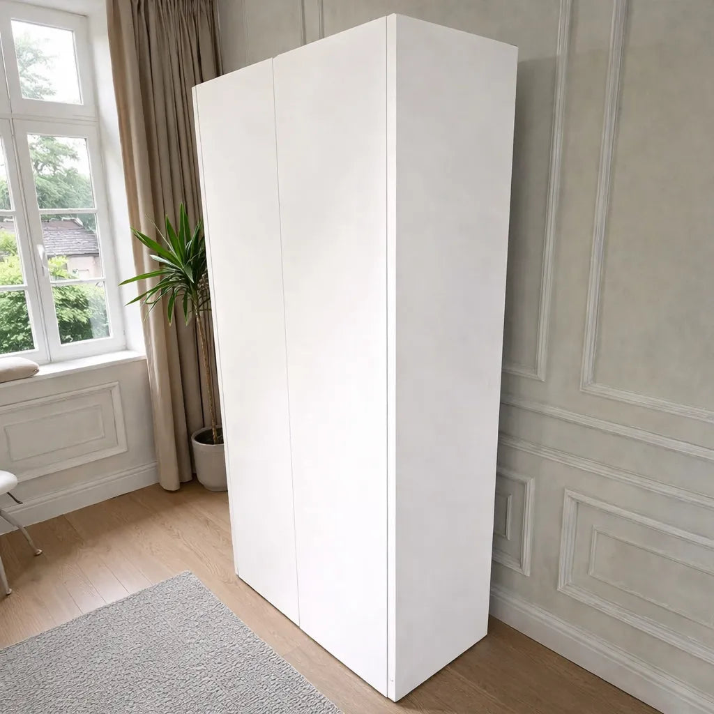 Vista posterior y lateral del armario Ambienta Home Decor BP-2504: acabado blanco liso, mueble alto de 185 cm, ancho 90 cm y fondo 45 cm.