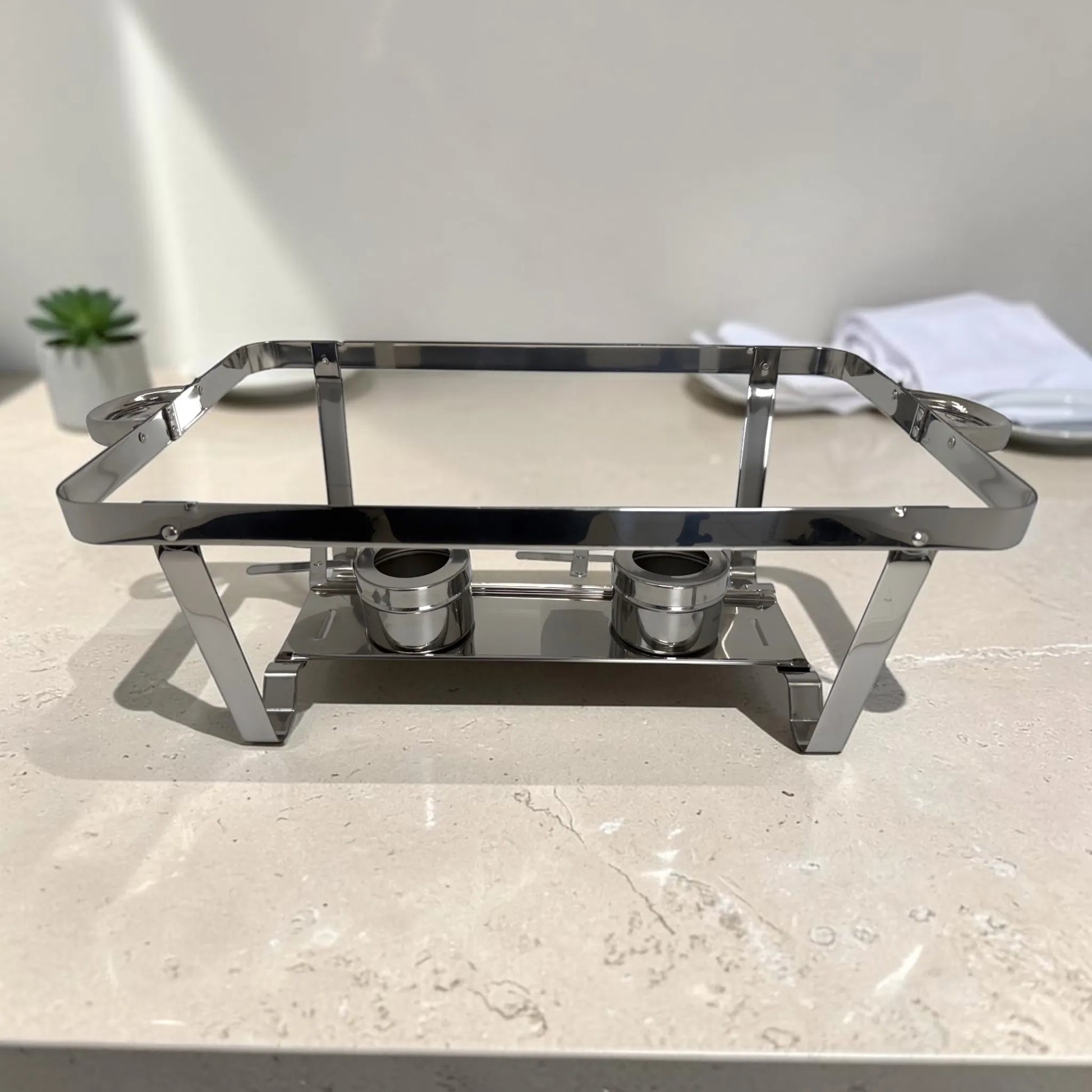Base de chafing dish de acero inoxidable con estructura cromada, asas laterales y dos quemadores inferiores.
