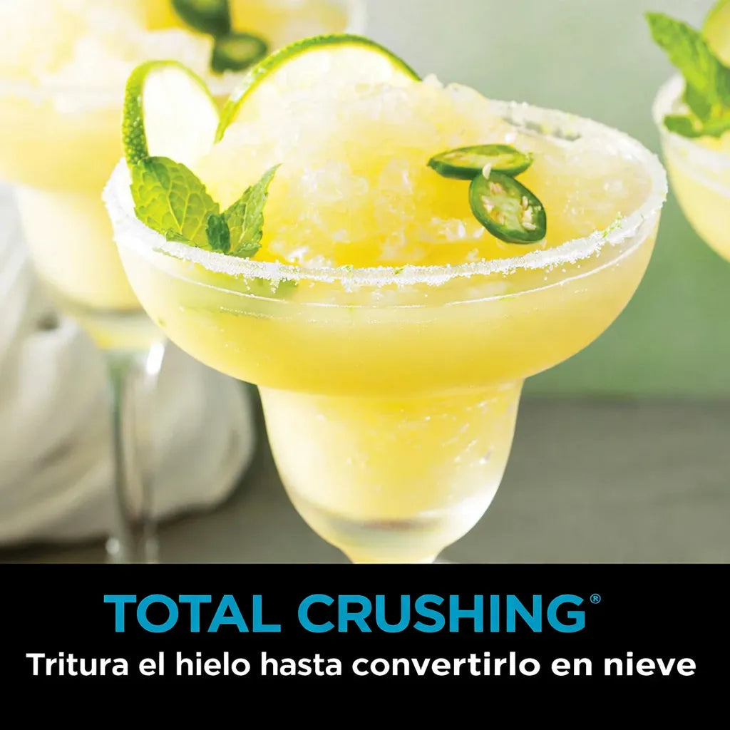 Bebida congelada amarilla tipo margarita con hielo triturado fino, lima y hojas de menta, representando la función Total Crushing de la licuadora Ninja BN701.