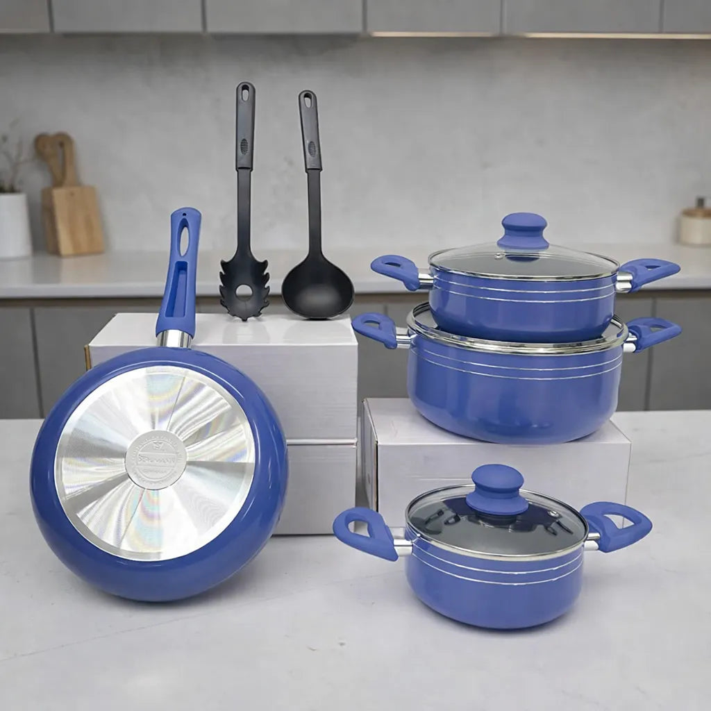 Batería de cocina Bergmann azul con ollas apiladas, cacerola con tapa y sartén; utensilios incluidos en escena de cocina.