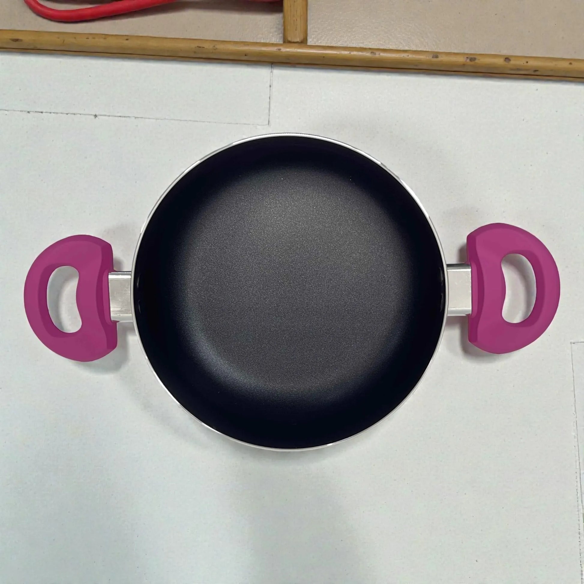 Cacerola u olla Bergmann antiadherente color fucsia, vista superior del interior con recubrimiento antiadherente y asas laterales.