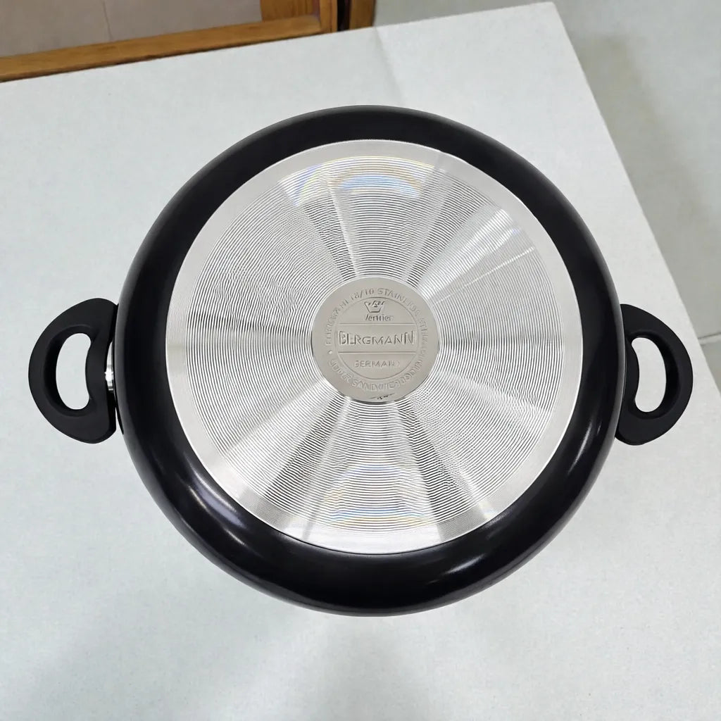 Base metálica de olla o cacerola Bergmann de aluminio antiadherente color negro con asas laterales, vista inferior mostrando difusor de calor.