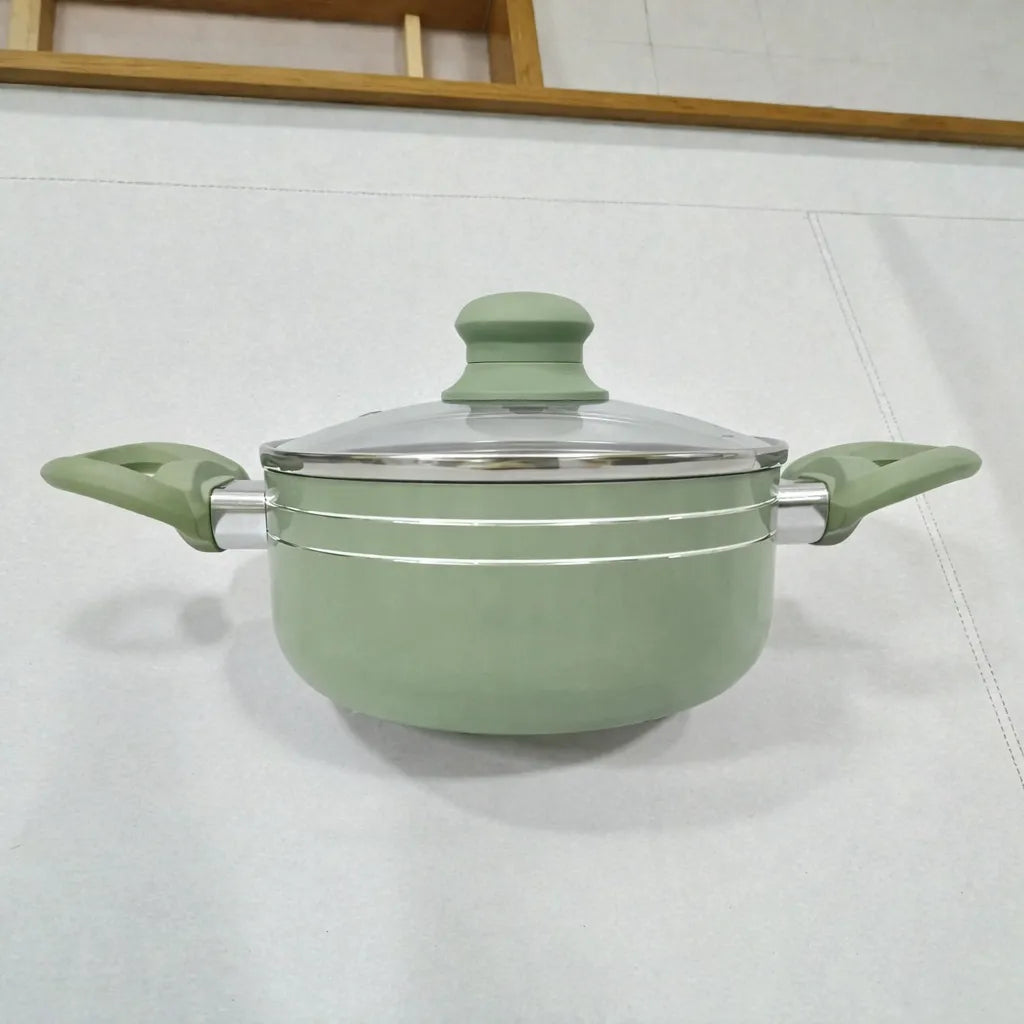 Olla Bergmann verde oliva con tapa de vidrio y asas laterales, diseño moderno con detalles metálicos.