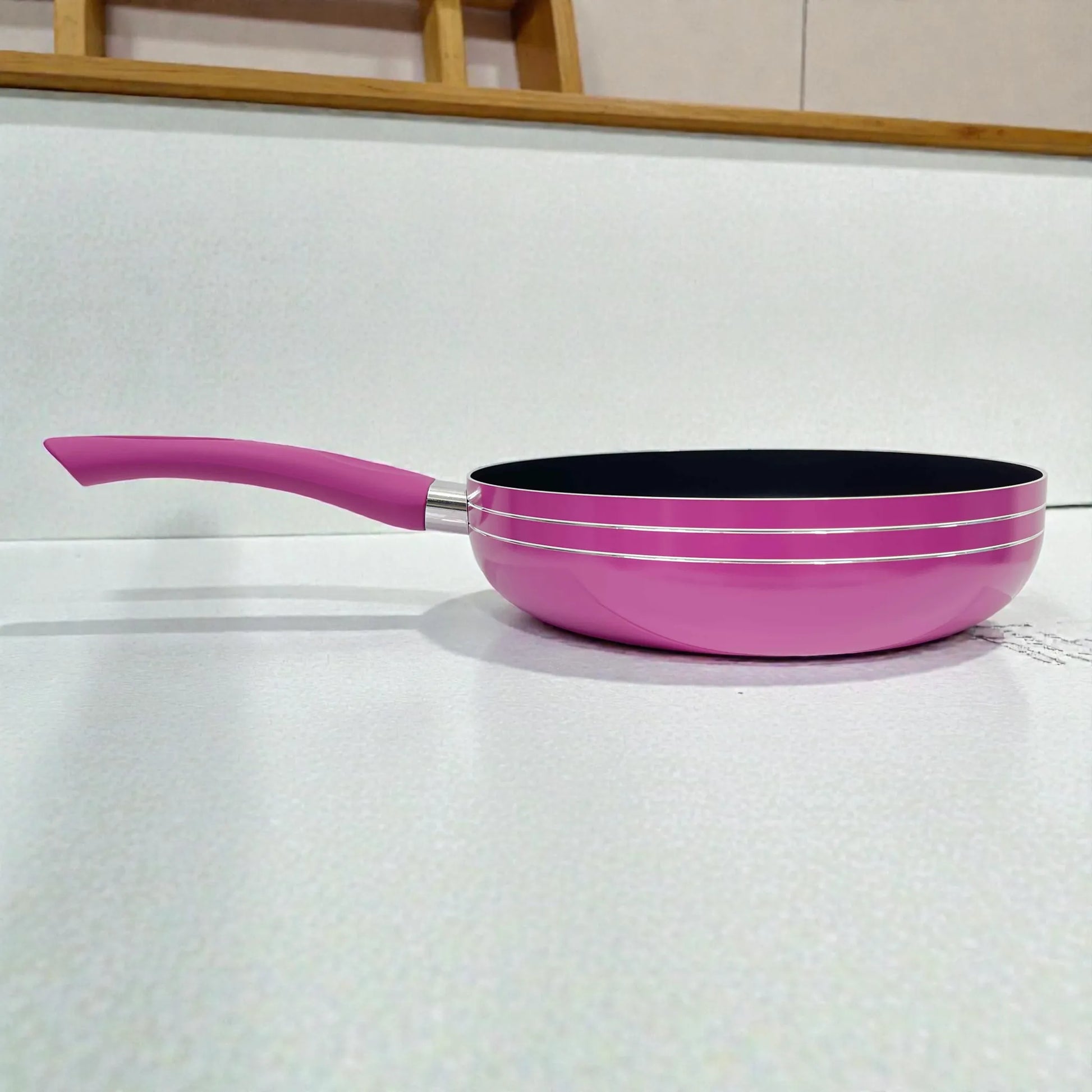 Sartén Bergmann 24 cm de aluminio antiadherente color fucsia con mango ergonómico, vista lateral mostrando altura y forma del borde.