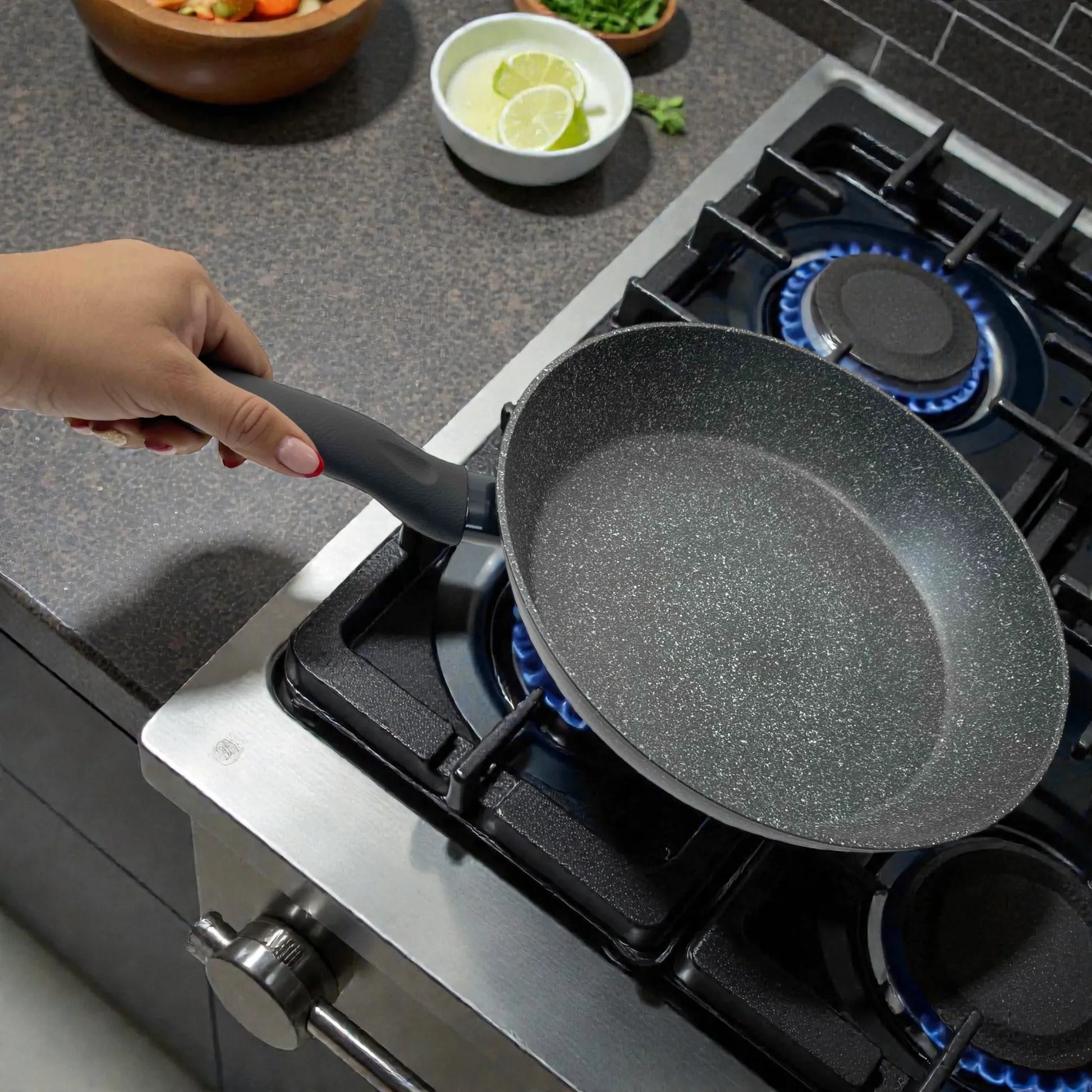 Sartén Bergner Orion Ø32 cm aluminio forjado con recubrimiento Marble+ gris, mostrada inclinada sobre estufa de gas para resaltar profundidad.