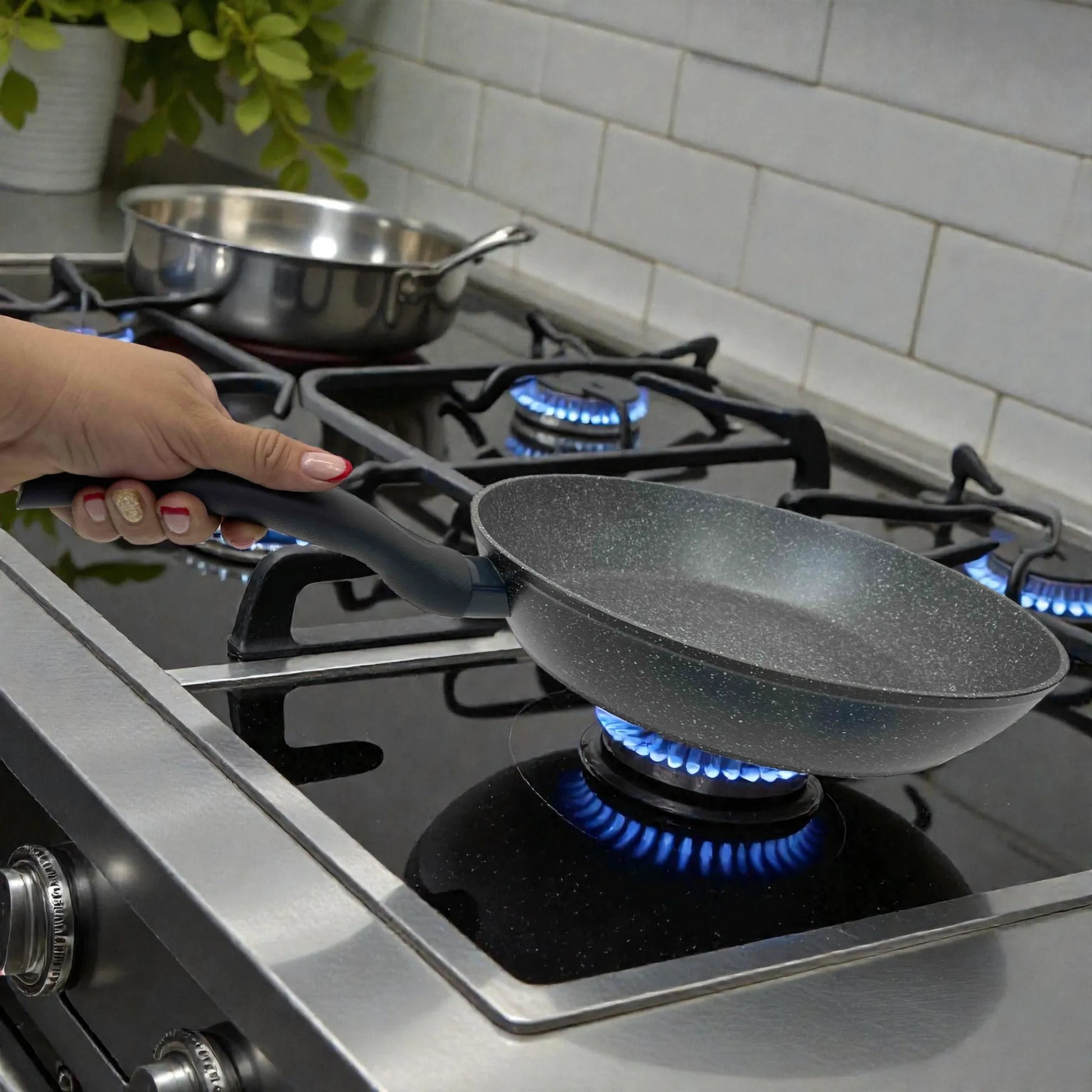 Vista lateral de sartén Bergner Orion Ø32 cm gris jaspeado con antiadherente Marble+ en estufa de gas; mango soft-touch en uso.