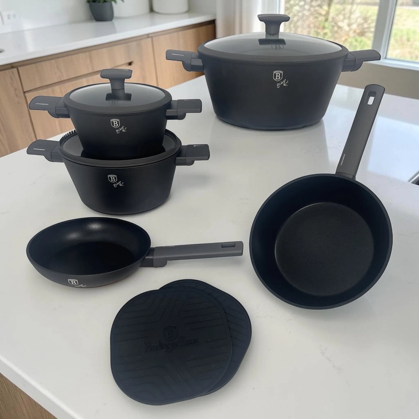 Juego de ollas y sartenes Berlinger Haus Anthracite Collection BH-8140NN de 10 piezas con cacerolas, sartenes y tapetes de silicona en cocina moderna.