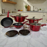 Set de cookware Berlinger Haus Metallic Line Burgundy de 10 piezas en color borgona, con 3 cacerolas con tapa (20, 24 y 28 cm), sarten honda 24 cm, sarten 20 cm y 2 bases de baquelita, presentado sobre encimera en cocina.