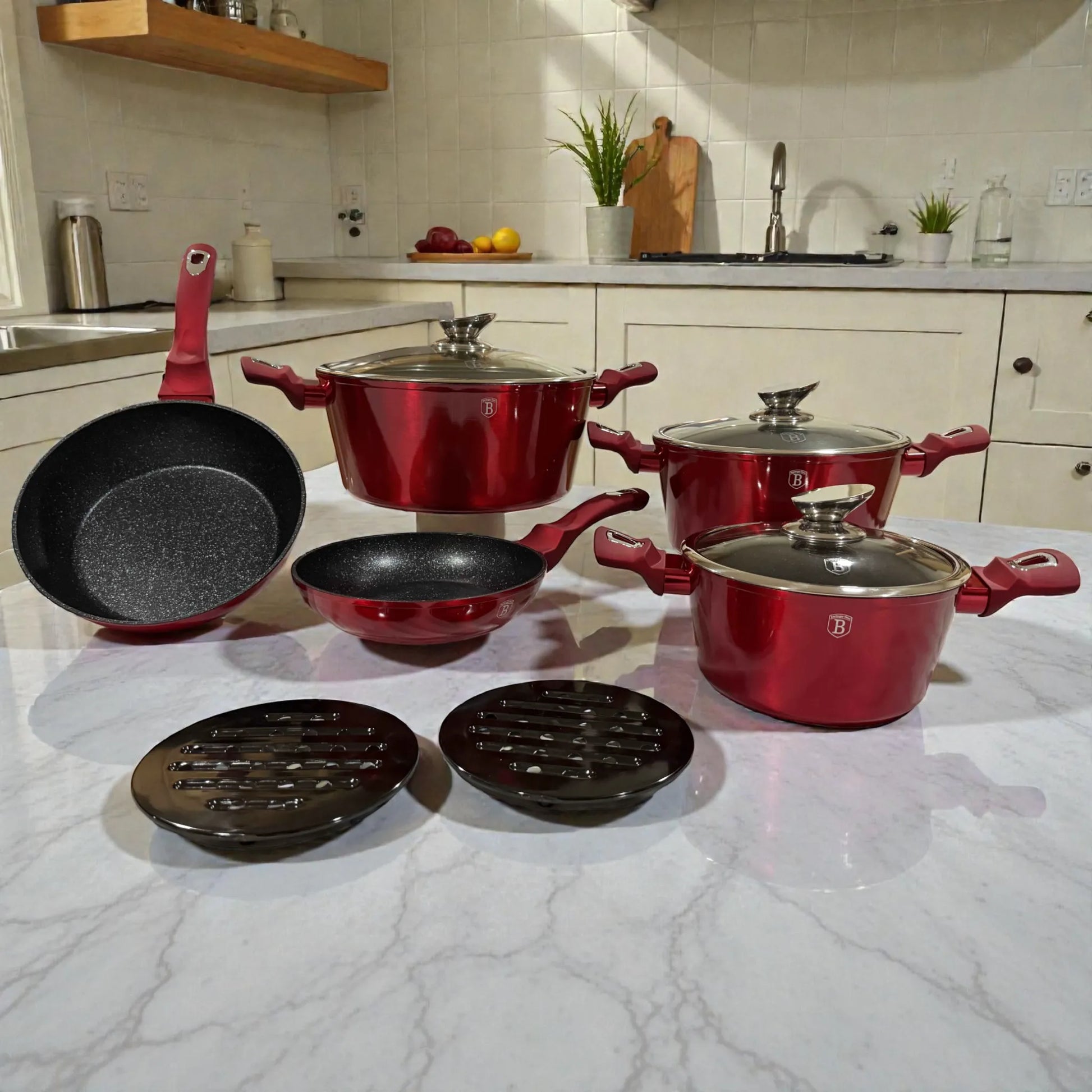 Set de cookware Berlinger Haus Metallic Line Burgundy de 10 piezas en color borgona, con 3 cacerolas con tapa (20, 24 y 28 cm), sarten honda 24 cm, sarten 20 cm y 2 bases de baquelita, presentado sobre encimera en cocina.