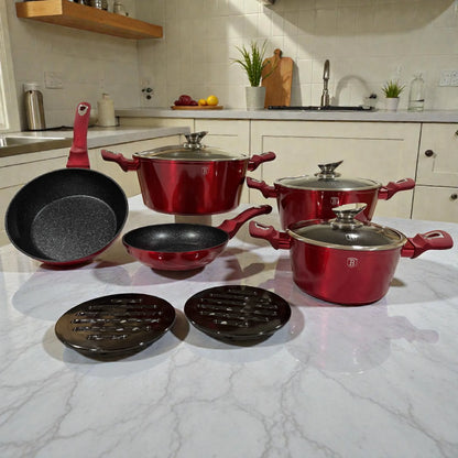 Set de cookware Berlinger Haus Metallic Line Burgundy de 10 piezas en color borgona, con 3 cacerolas con tapa (20, 24 y 28 cm), sarten honda 24 cm, sarten 20 cm y 2 bases de baquelita, presentado sobre encimera en cocina.
