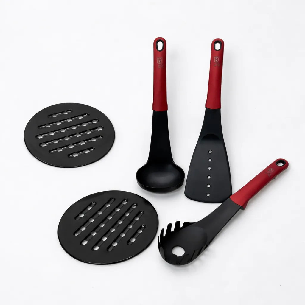 Utensilios de cocina Berlinger Haus Metallic Line Burgundy con mangos rojos y cabezales negros (cucharón, espátula, cuchara para pasta) junto a dos salvamanteles redondos.